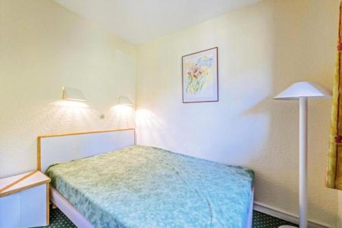 - une petite chambre avec un lit et une lampe dans l'établissement Résidence Le Hameau du Sauget - maeva Home - 2 Pièces 4 Personnes Confort MAE-6712, à La Plagne Tarentaise