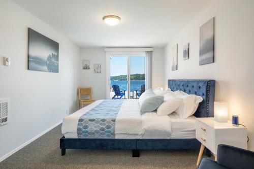 een slaapkamer met een bed en uitzicht op de oceaan bij 116 - Inviting Waterfront Haven BBQ in Gig Harbor