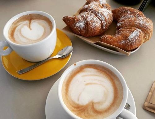 two cups of coffee and pastries on a table at Dolce Dormire in Enna