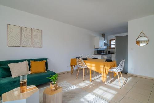 un soggiorno con divano verde e tavolo di Le Rooftop Saint Charles parking privé a Marsiglia