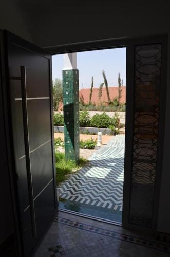 an open glass door with a view of a courtyard at Villa Palmengarten Meknès bei Fes in Meknès