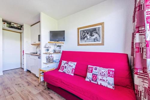 - un canapé rouge dans une chambre avec cuisine dans l'établissement Résidence Le Sextant - maeva Home - Studio 4 Personnes Sélection MAE-6066, à La Plagne Tarentaise