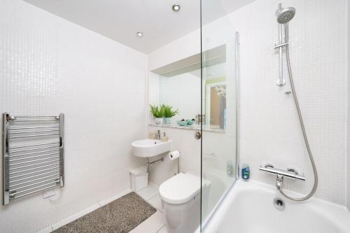 a bathroom with a shower and a toilet and a sink at COBALT POINT, South Quay in London