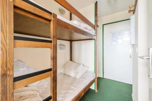 Ce lit superposé se trouve dans une petite chambre dotée d'une moquette verte. dans l'établissement Résidence Les Alpages - maeva Home - Studio 4 Personnes Budget MAE-9784, à Morzine