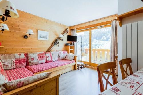 un salon avec un canapé et une fenêtre dans l'établissement Résidence Les Sentiers du Tueda - maeva Home - 2 Pièces 6 Personnes Prestige MAE-2427, à Les Allues