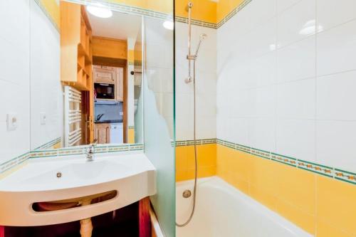 uma casa de banho com um lavatório e um chuveiro em Résidence Les Sentiers du Tueda - maeva Home - 2 Pièces 6 Personnes Prestig 27 em Les Allues