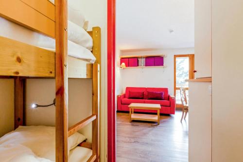 a room with bunk beds and a red couch at Résidence Les Ravines - maeva Home - Studio 4 personnes - Confort 87 in Les Allues