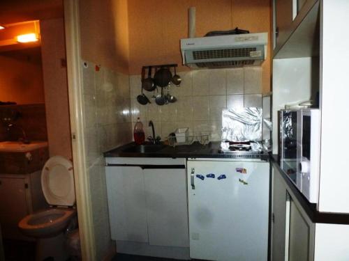 Elle comprend une petite cuisine équipée d'un réfrigérateur blanc et d'un évier. dans l'établissement Résidence Le Lys - Studio 4 Personnes MAE-4135, à Cauterets