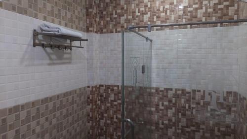 a bathroom with a shower with a glass door at Javson Airport Hotel in Sialkot