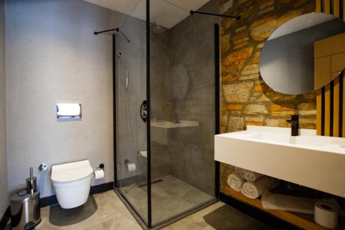 een badkamer met een douche, een toilet en een wastafel bij Asterina Hotel in Turgutreis