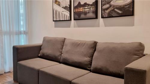 a brown couch in a living room with pictures on the wall at Wyndham Rio Barra in Rio de Janeiro