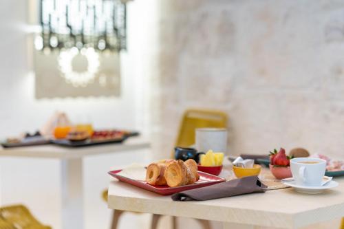 a table with a plate of pastries on a table at Vico Bianco Raro Smart Rooms Collection in Ostuni