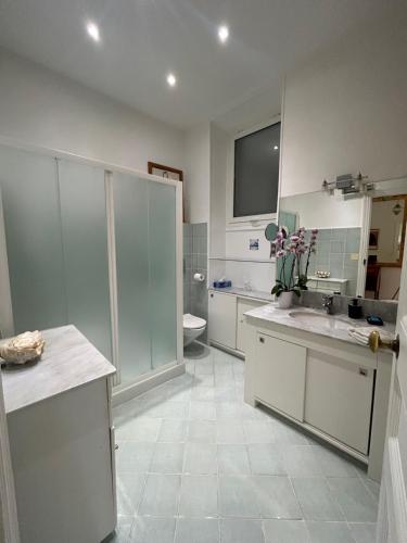 une salle de bain blanche avec un lavabo et des toilettes dans l'établissement Ancien Palace 4couchages Vue Mer, à Menton