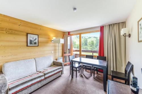 un salon avec un canapé et une table dans l'établissement Résidence Le Quartz - maeva Home - 2 Pièces 4 Personnes Sélection MAE-3890, à La Plagne Tarentaise