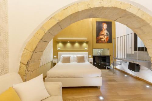 una camera con letto in una stanza con arco di Martini Rooms Castello a Cagliari