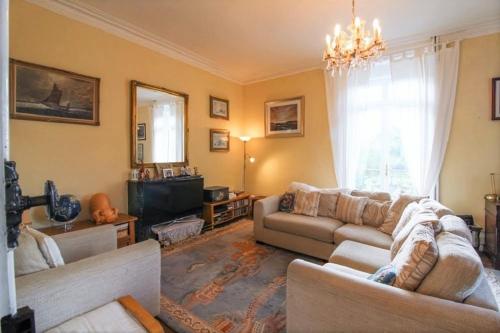 ein Wohnzimmer mit zwei Sofas und einem Fernseher in der Unterkunft Grande maison de charme, 14 pers. 5 chambres, sauna, écrin de verdure, baby foot in Saint-Clémentin