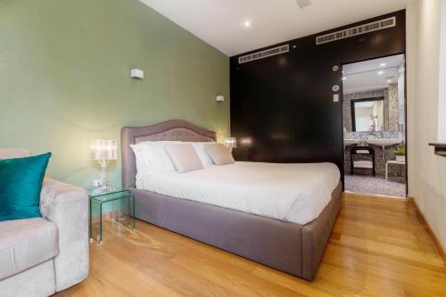 een slaapkamer met een bed, een bank en een tafel bij Martini Rooms Castello in Cagliari