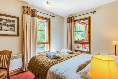 une chambre avec un lit et deux fenêtres dans l'établissement Résidence Les Arcs 1950 Le Village - maeva Home - 3 Pièces 6 Personnes Sélection MAE-4294, à Bourg-Saint-Maurice
