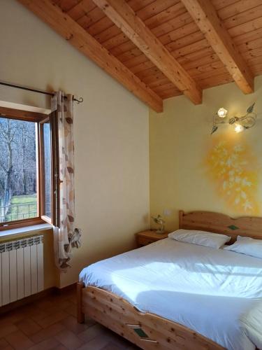 um quarto com uma cama e uma janela em Agriturismo Trapletti em Serina