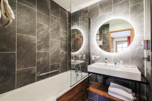 une salle de bain avec un lavabo et un miroir dans l'établissement Résidence Les Arcs 1950 Le Village - maeva Home - 3 Pièces 6 Personnes Exclusive MAE-6150, à Bourg-Saint-Maurice