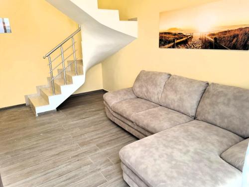 a living room with a couch and a staircase at Apart-Hotel Panorama Sea LUX in Primorsko
