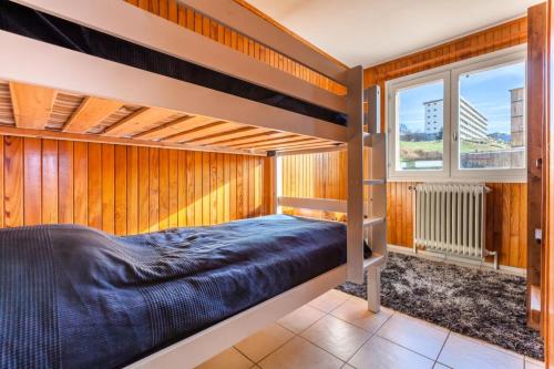 1 dormitorio con 2 literas y ventana en Appartement 6 pers. à 30m des remontées - Maeva Particuliers - 3 Pièces 6 Personnes Sélection 138716 en L'Alpe-d'Huez