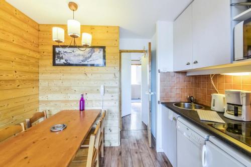 une cuisine avec des armoires blanches et un comptoir en bois dans l'établissement Résidence Les Constellations - maeva Home - Studio 5 Personnes Sélection MAE-8748, à La Plagne Tarentaise