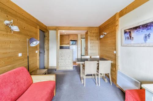 un salon avec un canapé rouge et une table dans l'établissement Résidence Les Néreïdes - maeva Home - 2 Pièces 5 Personnes Sélection MAE-8709, à La Plagne Tarentaise