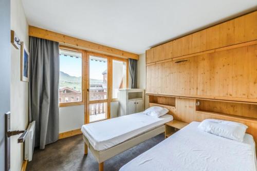 une chambre avec deux lits et une fenêtre dans l'établissement Résidence Les Néreïdes - maeva Home - 2 Pièces 5 Personnes Sélection MAE-8709, à La Plagne Tarentaise