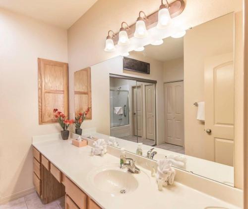 a bathroom with a sink and a large mirror at Branson Condo with a Walkout and Elevator Access at Thousand Hills and next to 76 in Branson