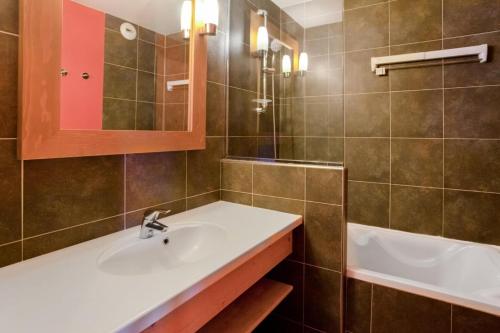 une salle de bain avec un lavabo et une baignoire dans l'établissement Résidence Aconit - maeva Home - 2 Pièces 4 Personnes Sélection MAE-8881, aux Menuires