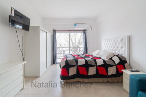 een witte slaapkamer met een bed en een raam bij MONOAMBIENTE38 in La Plata