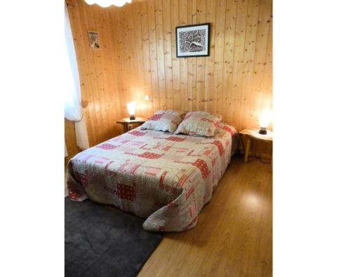 モルジヌにあるChalet 8 pers. avec terrasse 69571の木製の壁のベッドルーム1室