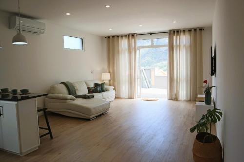 uma sala de estar com um sofá branco e uma grande janela em A Casa Da Mãe em São Vicente