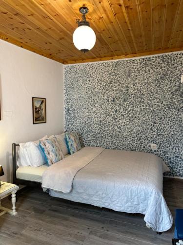 a bedroom with a bed in a room with a wall at Old Town Traditional Residence in Kavala