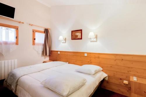 une chambre avec un grand lit avec des draps blancs dans l'établissement Résidence La Marelle et Le Rami - maeva Home - 2 pièces 5 Personnes Prestige MAE-9396, à La Plagne Tarentaise