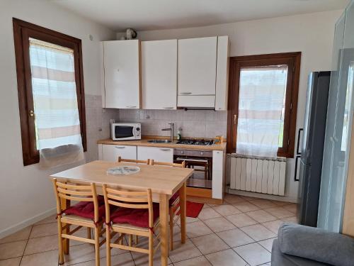 a kitchen with white cabinets and a table and chairs at Casa Ida in Scaltenigo