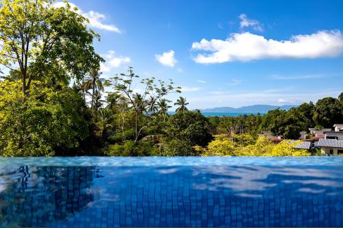 a swimming pool with a view of the forest at Blue Elephant Villa Koh Phangan in Haad Pleayleam
