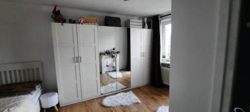 a bedroom with white cabinets and a mirror at Vöckla - Appartement in Timelkam