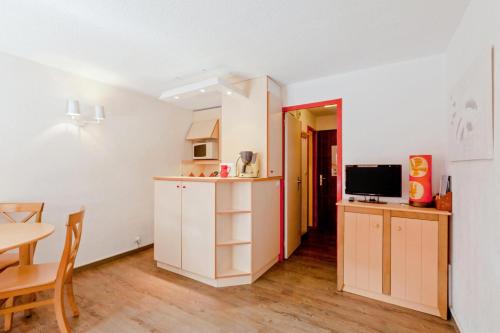 une petite cuisine avec une table et une salle à manger dans l'établissement Résidence Les Ravines - maeva Home - Studio 4 Personnes Confort MAE-9397, à Les Allues