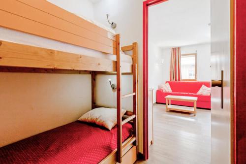 Zimmer mit einem Etagenbett und einem roten Sofa in der Unterkunft Résidence Les Ravines - maeva Home - Studio 4 Personnes Confort 97 in Les Allues