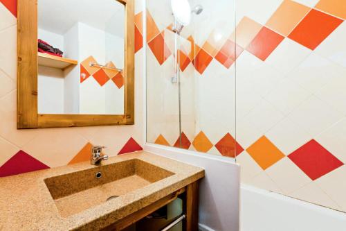 ein Bad mit einem Waschbecken und einem Spiegel in der Unterkunft Résidence Les Ravines - maeva Home - Studio 4 Personnes Confort 97 in Les Allues