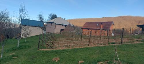 a fence in the middle of a field with houses at Firefly in Bijelo Polje