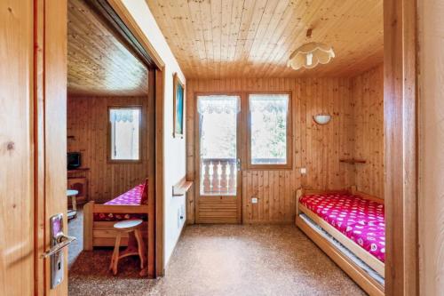 une chambre avec deux lits dans une cabane en bois dans l'établissement Chalet le Séchet - maeva Home - 2 Pièces 4 personnes Confort MAE-0615, à Bellentre