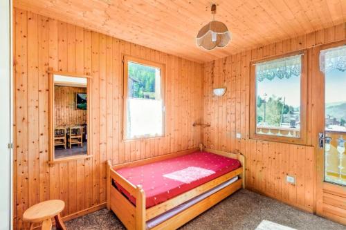 ein Schlafzimmer mit einem Bett in einem Holzzimmer in der Unterkunft Chalet le Séchet - Maeva Particuliers - 2 pièces 4 Personnes Confort 140621 in Bellentre