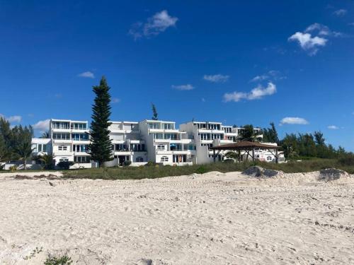 un gran edificio de apartamentos blanco en la playa en Wake Up To The Sounds Of The Sea, en Freeport