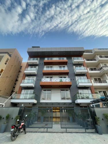 a building with a motorcycle parked in front of it at Saltstayz Premier - Near Golf Course Road & Sector 57 in Gurgaon