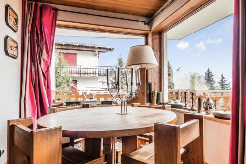 une salle à manger avec une table et des chaises et une grande fenêtre dans l'établissement Appartement 6 pers. belle vue montagne - maeva Home - Appartement 3 Pièces 6 Personnes - Sélection MAE-0673, à Font-Romeu-Odeillo-Via