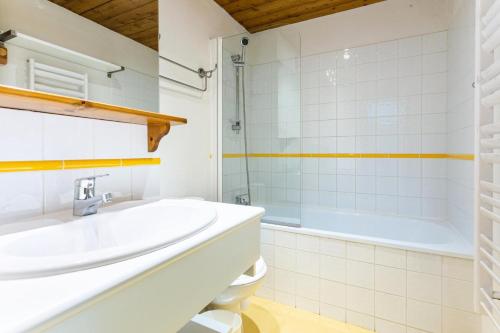 a white bathroom with a sink and a tub at Quartier La Forêt - maeva Home - 3 Pièces 6 Personnes Sélection 41 in Valmorel