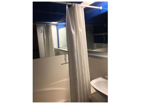 une salle de bain avec un rideau de douche et un lavabo dans l'établissement Résidences quartier Charmettoger - maeva Home - 2 Pièces 6 Personnes Budget MAE-3507, à Arc 1800